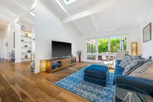 a living room with a blue couch and a tv at Lighthouse Beach Luxury in Port Macquarie