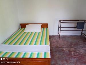 a bedroom with a bed with a striped mattress at Galle Side HomeStay in Galle
