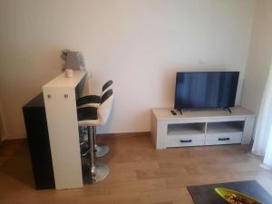 a living room with a television and a chair at studio à proximité de Genève in Étrembières