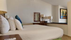 a bedroom with a bed with white sheets and pillows at Punta Pescadero Paradise Hotel & Villas in Los Barriles +107 photos