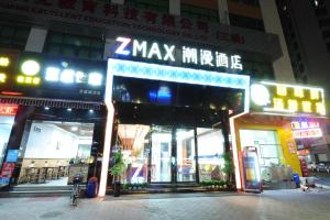um grupo de frentes de loja em uma cidade à noite em Chao Man Hotel - Guangzhou Railway Station Sanyuanli Metro Station em Guangzhou