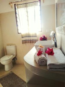 a bathroom with a sink and a toilet and towels at Shira house in Watamu