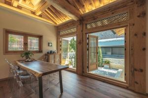 a dining room with a table and a large window at Hongsi Art House in Gongju