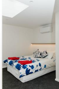 een slaapkamer met een bed met een blauwe en witte deken bij The Nest Beach Getaway in Torquay