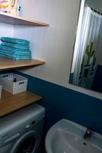 ein Badezimmer mit Waschmaschine und Waschbecken in der Unterkunft Apartamento con inmejorables vistas de la Barrosa in Chiclana de la Frontera