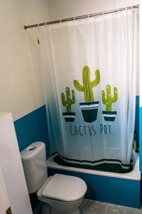 ein Badezimmer mit einem WC und einem Kaktus-Topf-Duschvorhang in der Unterkunft Apartamento con inmejorables vistas de la Barrosa in Chiclana de la Frontera + 15 Fotos