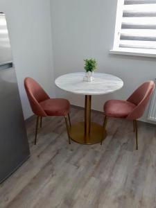 uma mesa com duas cadeiras e uma mesa com um vaso sobre ela em Ljubljana Central Studio with Free Parking em Ljubljana