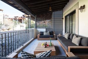 a patio with couches and a table on a balcony at Private Jacuzzi & Pool, Elegant La Escondida 5BR in San Miguel de Allende
