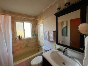 bagno con lavandino, servizi igienici e specchio di Cozy Double Room with a Garden and a Patio a Delta