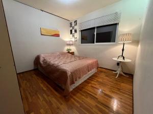 a small bedroom with a bed and a window at Cozy Double Room with a Garden and a Patio in Delta