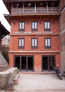 a red brick building with a motorcycle parked in front at Sweet Home Bhaktapur in Bhaktapur