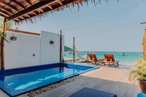 une villa avec une piscine à côté de l'océan dans l'établissement SeaSalt BeachFront Holiday Home, Private pool, 2 Bedroom house, à Chaloklum