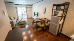 a living room with a table and a refrigerator at Le Bocage - Hakuba Echoland Chalets in Hakuba