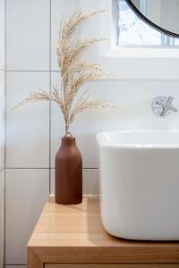 a vase with a plant sitting on a table in a bathroom at Walter Cottage As Cosy As It Is Convenient in Kings Park +28 photos