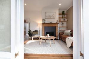 a living room with a couch and a table at Walter Cottage As Cosy As It Is Convenient in Kings Park