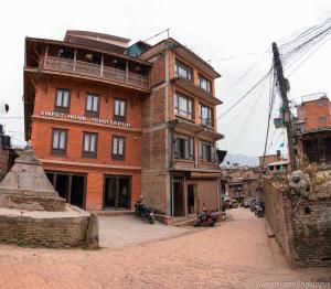 a brick building on a street with motorcycles in front at Sweet Home Bhaktapur in Bhaktapur