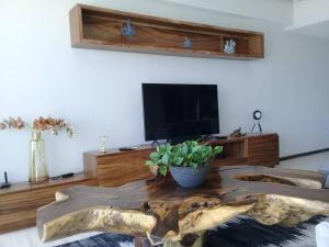 een woonkamer met een houten tafel en een televisie bij Increible vista en Bucerias en Narval Norte!!! in Bucerías