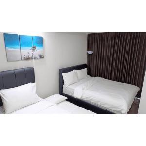 2 Betten nebeneinander in einem Zimmer in der Unterkunft Cityscape @ Caspian in Surabaya