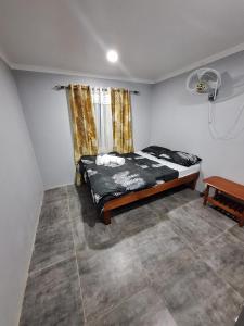 een slaapkamer met een bed in een kamer met een raam bij Mount Olivet House in Suva