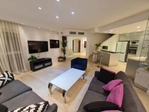 un soggiorno con divano e tavolo di Palmore Top Luxury Resort First line of the Seaside a Eilat