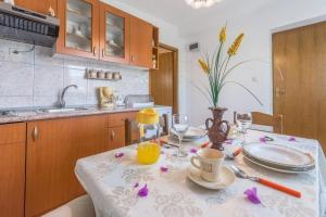 eine Küche mit einem Tisch und einem Tischtuch darauf in der Unterkunft Apartments Kosta - 70m from sea in Vinišće