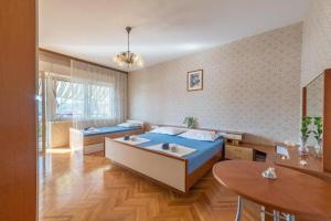 Schlafzimmer mit einem blauen Bett und einem Tisch in der Unterkunft Apartments Kosta - 70m from sea in Vinišće