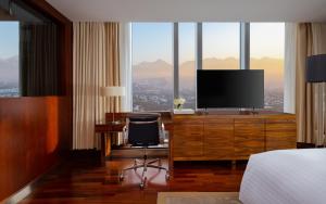 a hotel room with a television and a desk with a chair at The Ritz-Carlton, Almaty in Almaty