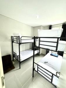 a room with three bunk beds in it at GreenLake Vista in Surabaya