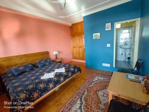 a bedroom with a bed and a bathroom with a sink at Jagatram Niwas in Dharamshala