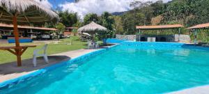 a large blue swimming pool in a resort at Cabaña rodeada de naturaleza in Cocorná