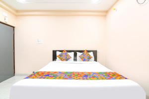 a bedroom with a large bed with colorful sheets at FabHotel Olive Inn I - 260m from Saltlake Sector V Metro Station in Kolkata