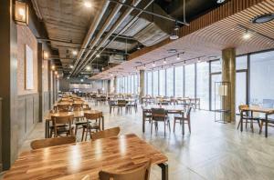 a restaurant with wooden tables and chairs and windows at S Hotel in Jeju
