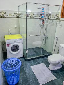 a bathroom with a shower and a washing machine at Shalom Villa in Rajagiriya
