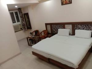 a bedroom with a large white bed in a room at Hotel Dada intdxin in New Delhi