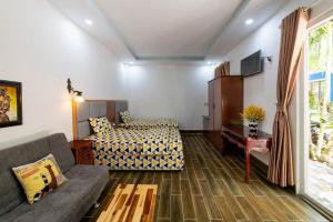 a living room with a couch and a bed at Coastal Village Phu Quoc in Phu Quoc