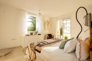 1 dormitorio con cama y ventana en Caesarea Sea-Side Exquisite Retreat by Sea N' Rent, en Cesarea