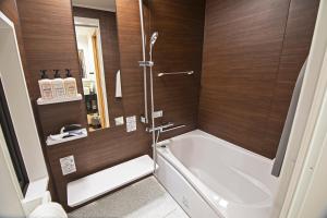a bathroom with a tub and a shower with wooden walls at -時の宿 上七軒- Kyoto Machiya 金閣寺周辺 in Kyoto +17 photos