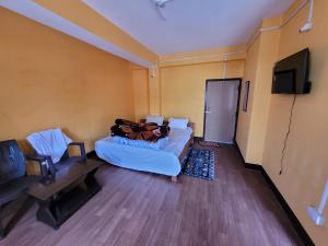 Namchibhardwaj hotel的房间里有一张床和一台平板电视