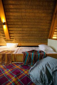 a bedroom with two twin beds and a rug at Bahay Artisano in El Nido