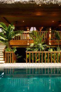 a resort with a swimming pool and a deck with plants at Bahay Artisano in El Nido