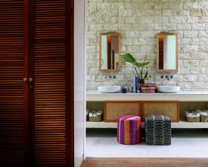 a bathroom with two sinks and two mirrors at Bahay Artisano in El Nido