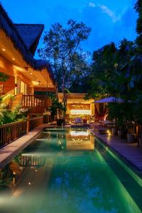 a swimming pool in the backyard of a house at night at Bahay Artisano in El Nido