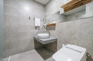 ein Bad mit einem WC und einem Waschbecken in der Unterkunft S Hotel in Jeju-do