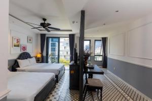 a hotel room with two beds and a table at Dérive Boutique Villa & Apartment Da Nang in Danang +56 photos