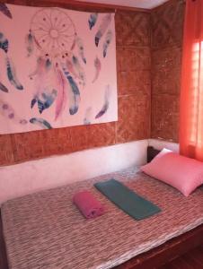 een kamer met een bed met een roze kussen en een tapijt bij Private Aircon Rooms in Lagkaw Homestay in Looc