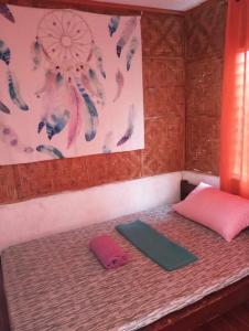 a room with a bed with a pink pillow and a rug at Private Aircon Rooms in Lagkaw Homestay in Looc