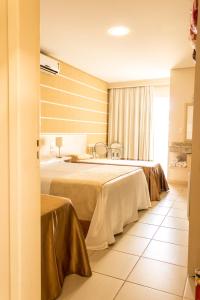 een hotelkamer met 2 bedden en een raam bij Pousada Cataratas in Foz do Iguaçu