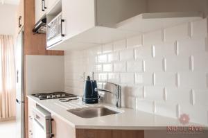 a white kitchen with a sink and a stove at Nid de Rêve Accomodation in Sandton