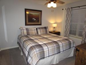 a bedroom with a bed with a plaid blanket at Lakefront Condo A-1 with Large Balcony in Hollister