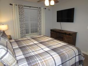a bedroom with a bed and a flat screen tv at Lakefront Condo A-1 with Large Balcony in Hollister